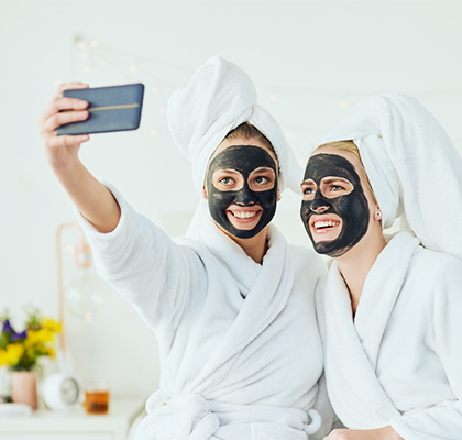Friends enjoy beauty masks together at home as part of their skincare routine. 